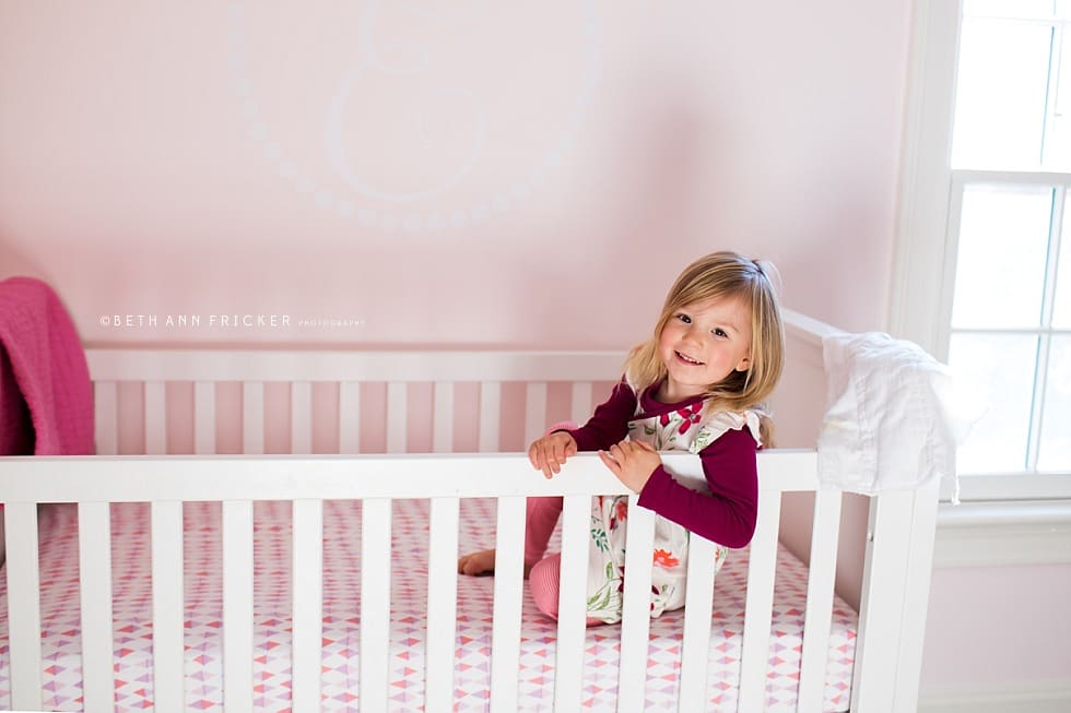 older sibling playing in the baby's crib Wellesley Newborn photographer