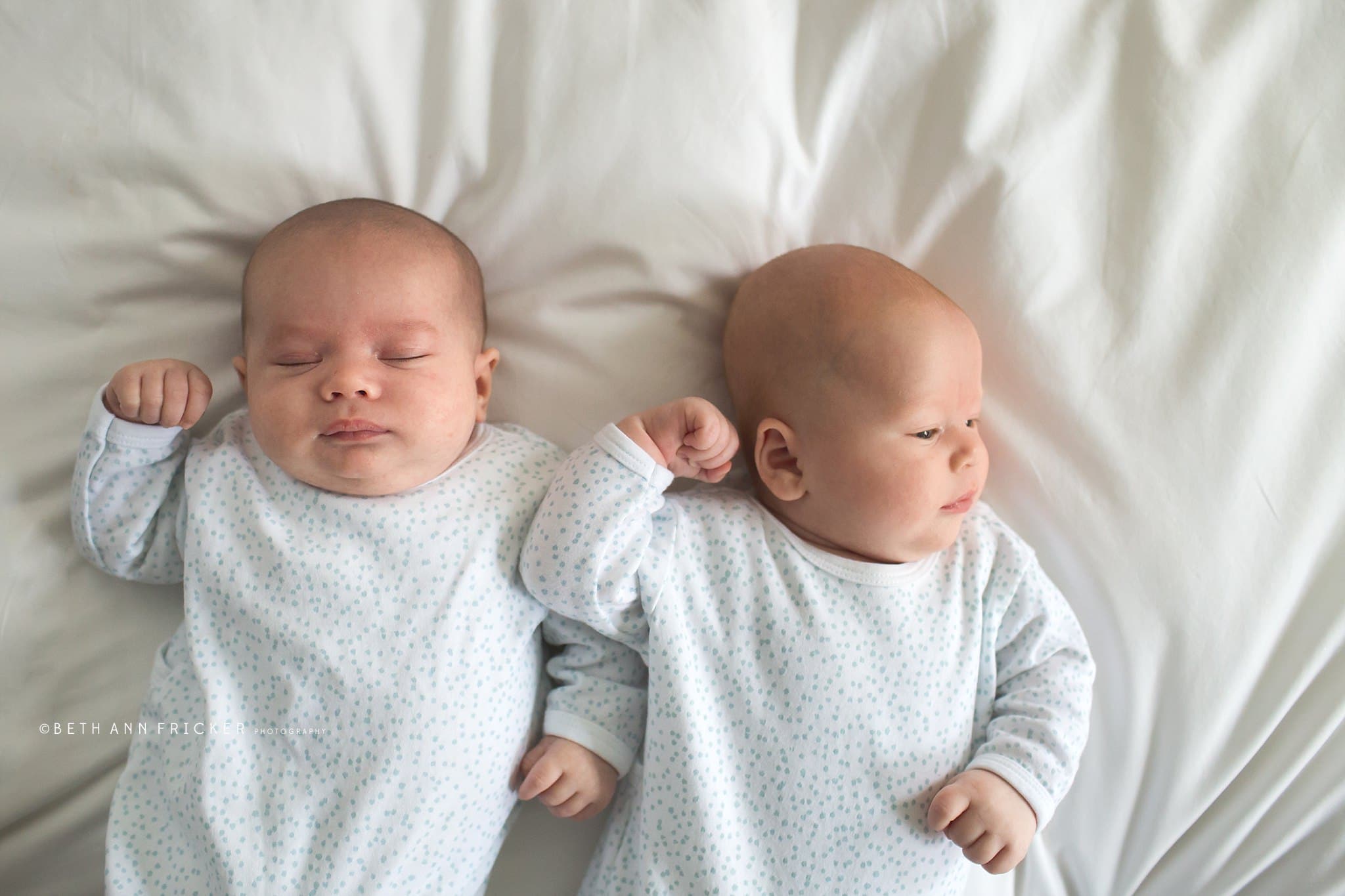 newborn twins laying on a bed Massachusetts Newborn Photographer
