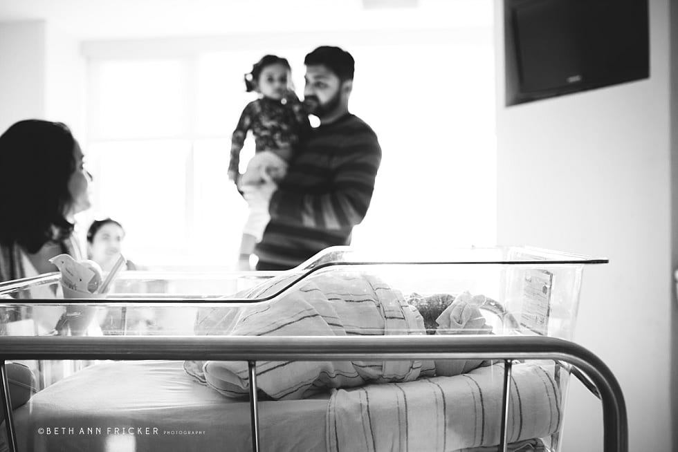 family at hosptial looking over newborn baby Boston newborn Photographer hospital session