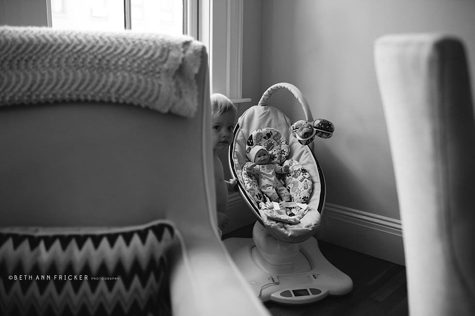 big brother peaking out behind a chair boston newborn photographer