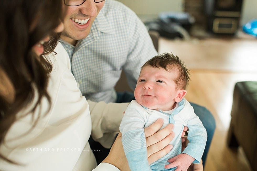 baby in mom and dad's arms smiling boston newborn photographer