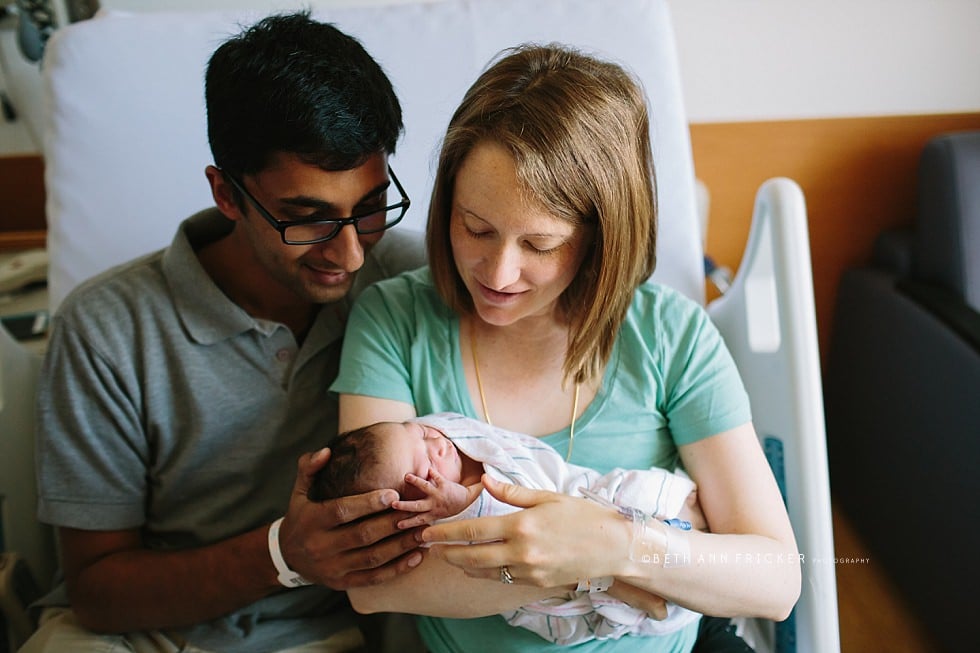 mom and dad holding newborn baby in the hospital Boston newborn photographer