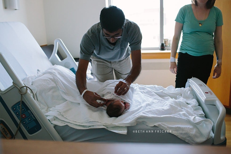 dad wrapping baby up in a swaddle in the hospital Boston newborn photographer