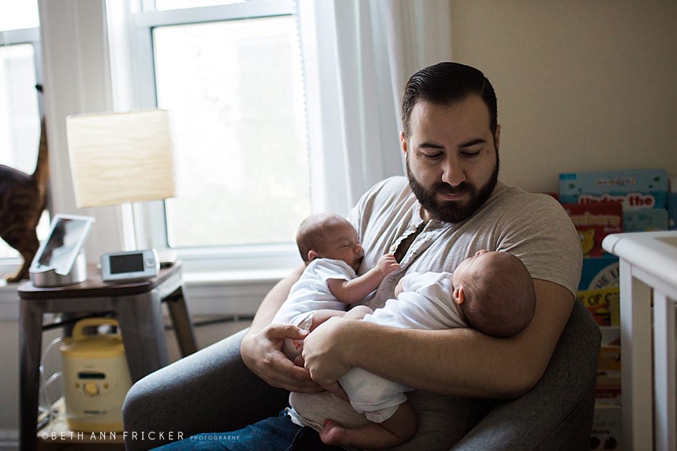 dad holding newborn twin sons Watertown Newborn Photographer