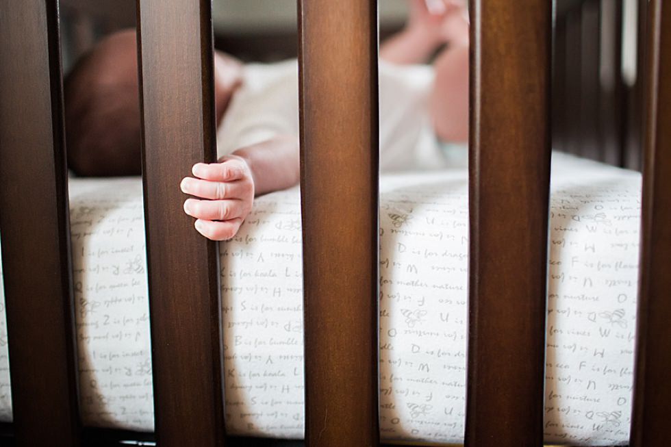 newborn baby boy's hands peeking through crib Boston Newborn photographer
