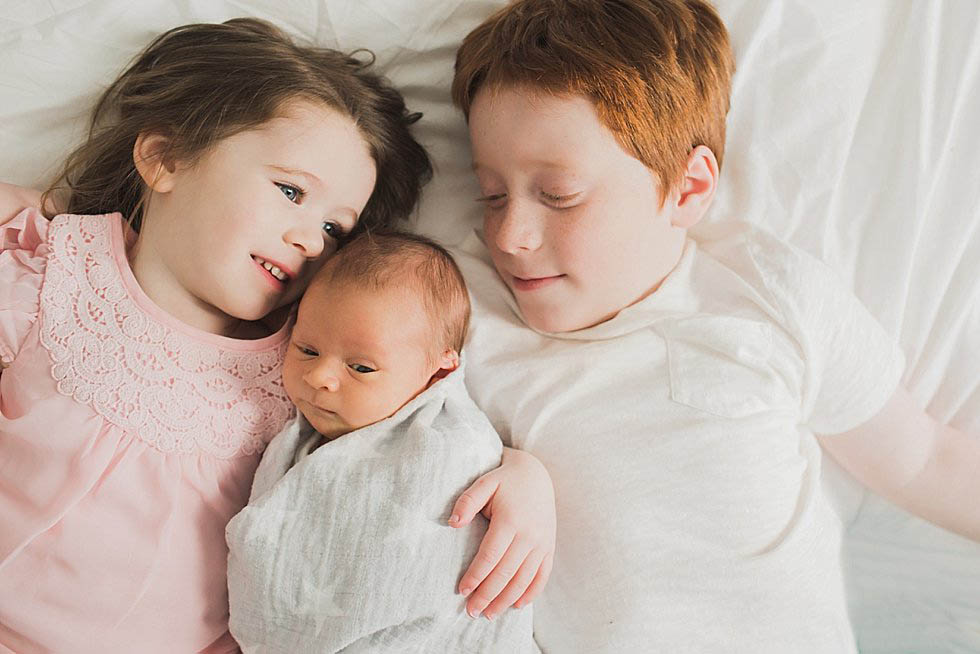 siblings holding baby at newborn session Newton Newborn Photographer