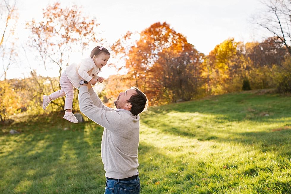 dad lifting up one year old in Energy filled fall family session