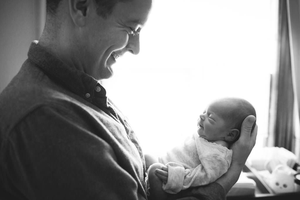 Dad holding and gazing at newborn baby daughter Boston Lifestyle Newborn Photos