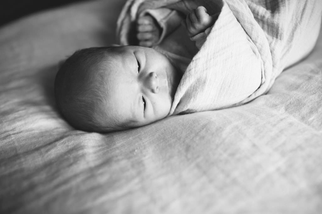 black and white image of baby on a bed Boston Lifestyle Newborn Photos