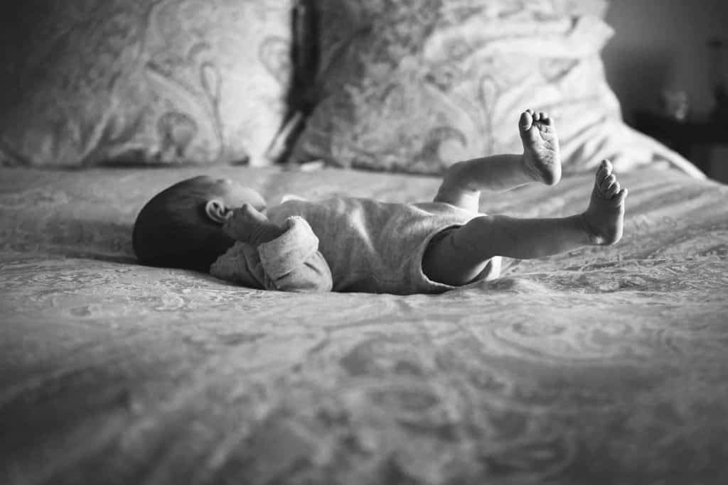 Newborn baby girl laying on bed Boston Newborn Photographer