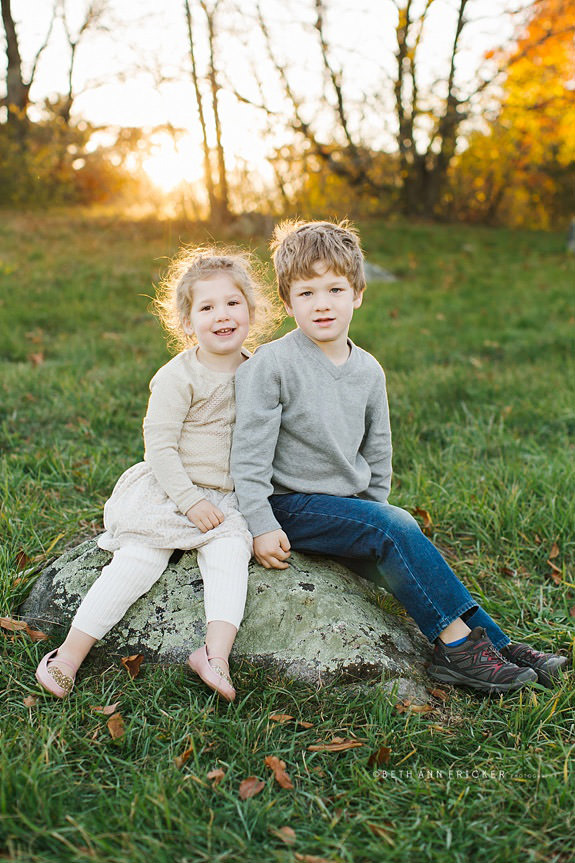 two kids sitting on a rock
