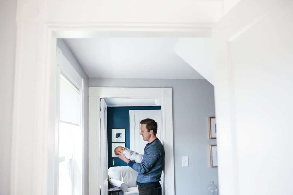 dad holding baby in the doorway Medford Newborn photographer