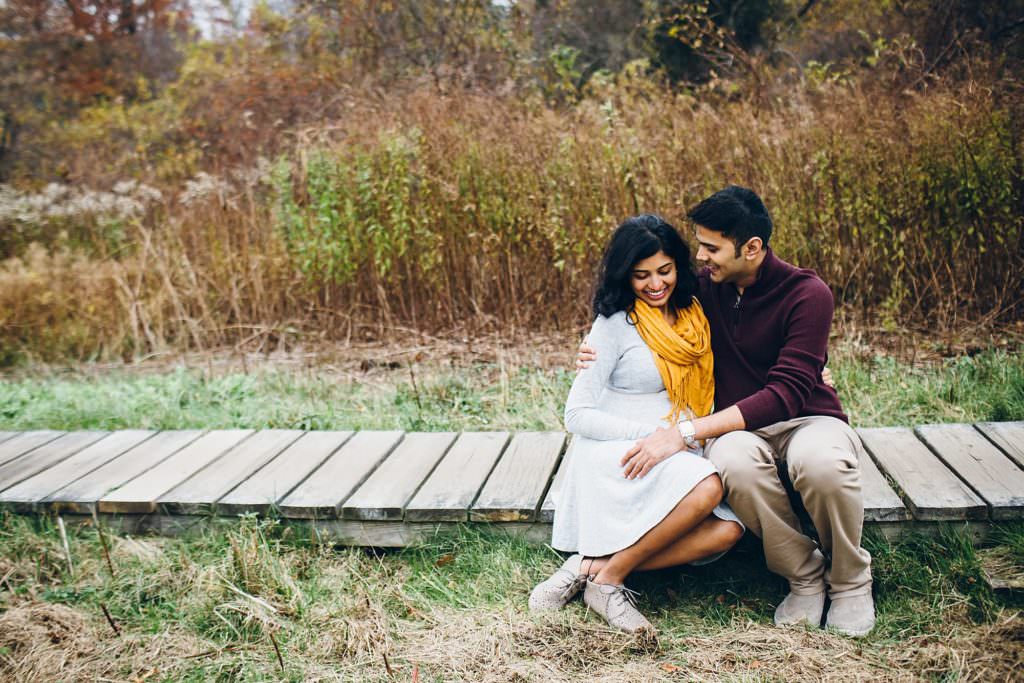 Pregnant mom looking at dad snuggling outside Boston Maternity photos