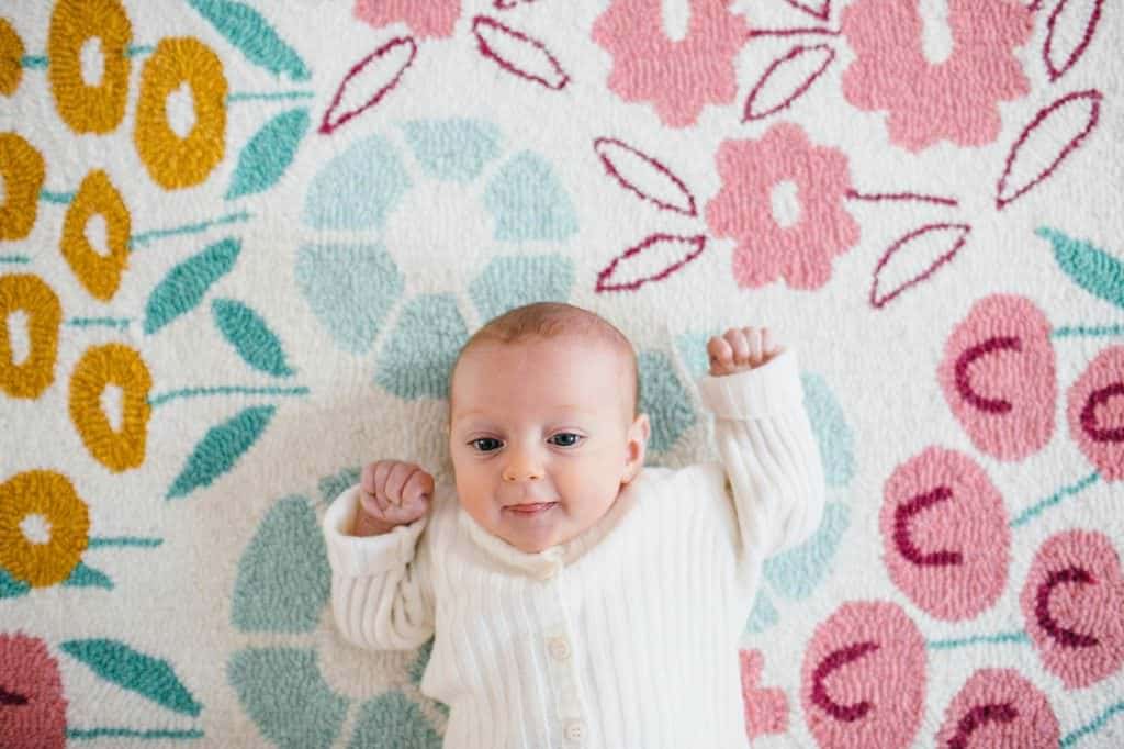 adorable baby on pink rug North Shore Newborn Photographer