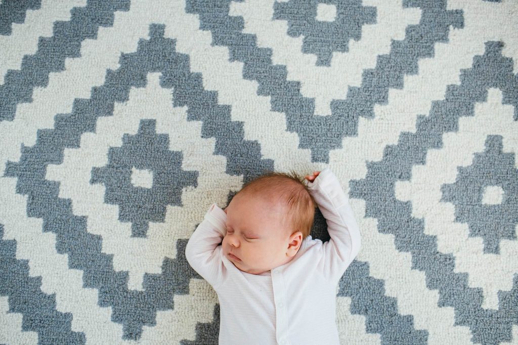 Baby lying on carpet Melrose newborn photographer