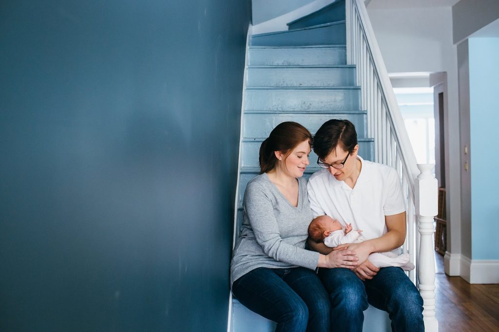 parents sitting on a stairwell Melrose newborn photographer