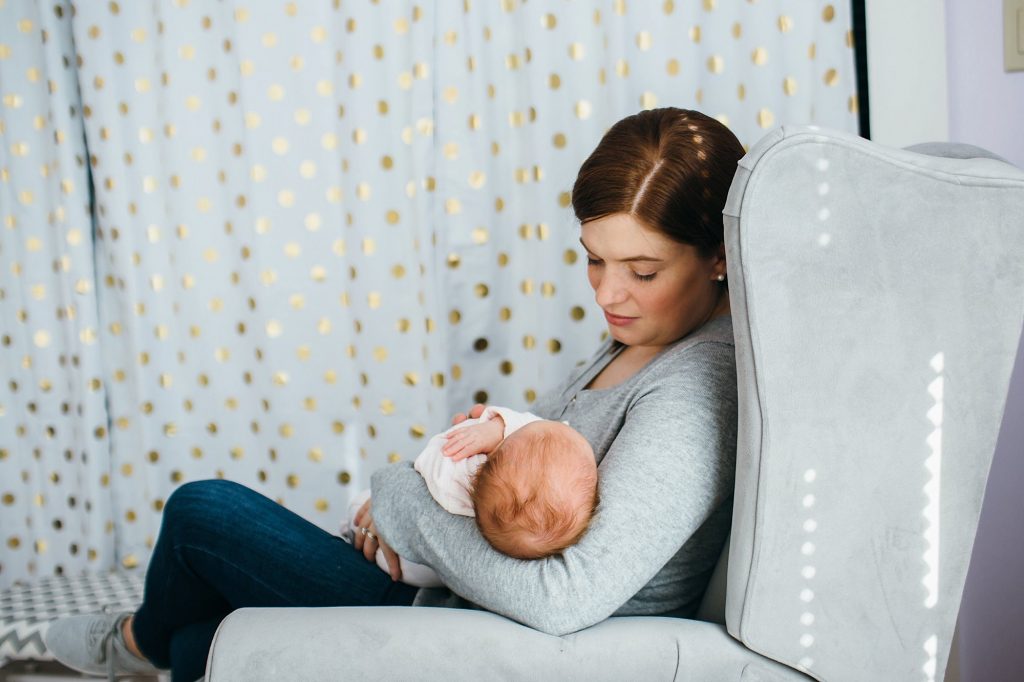 mom in nursery chair melrose newborn photographer