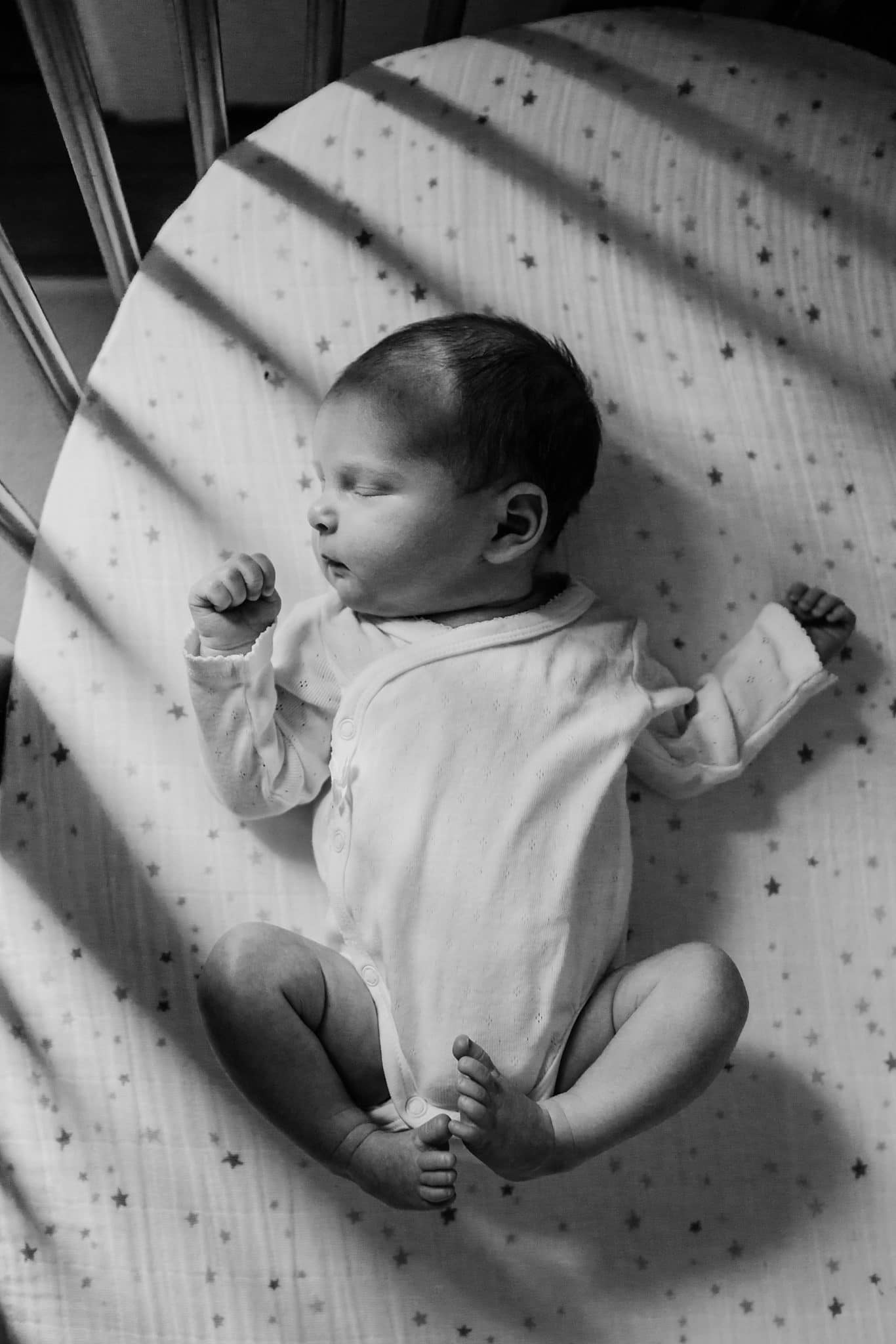 black and white photo of baby in crib dedham newborn photographer