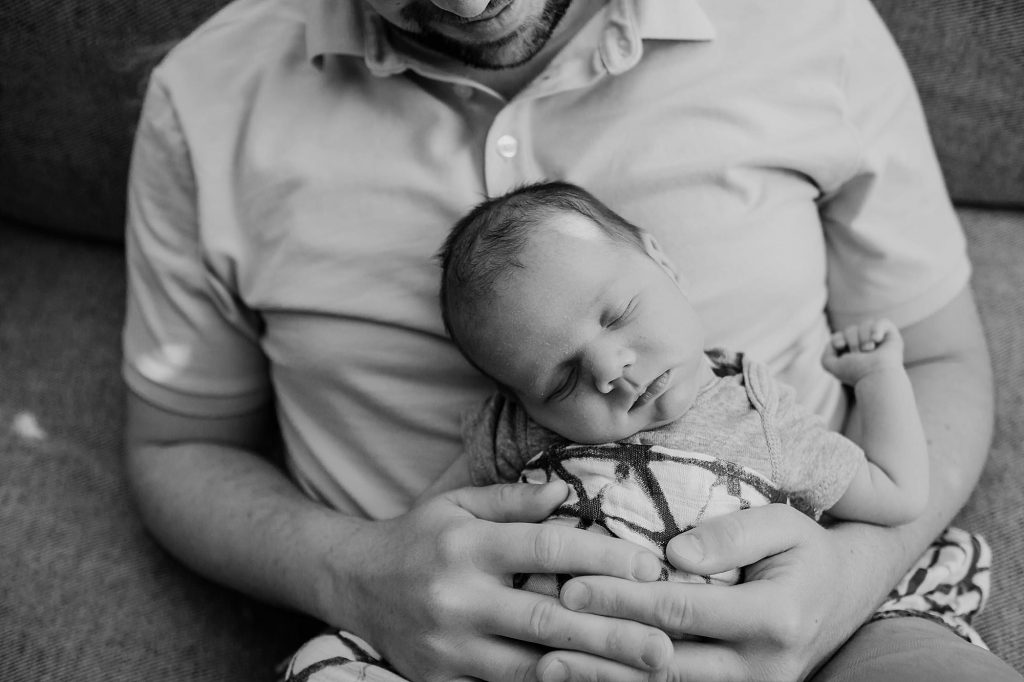 baby resting on dad's lap Newburyport Newborn Photographer