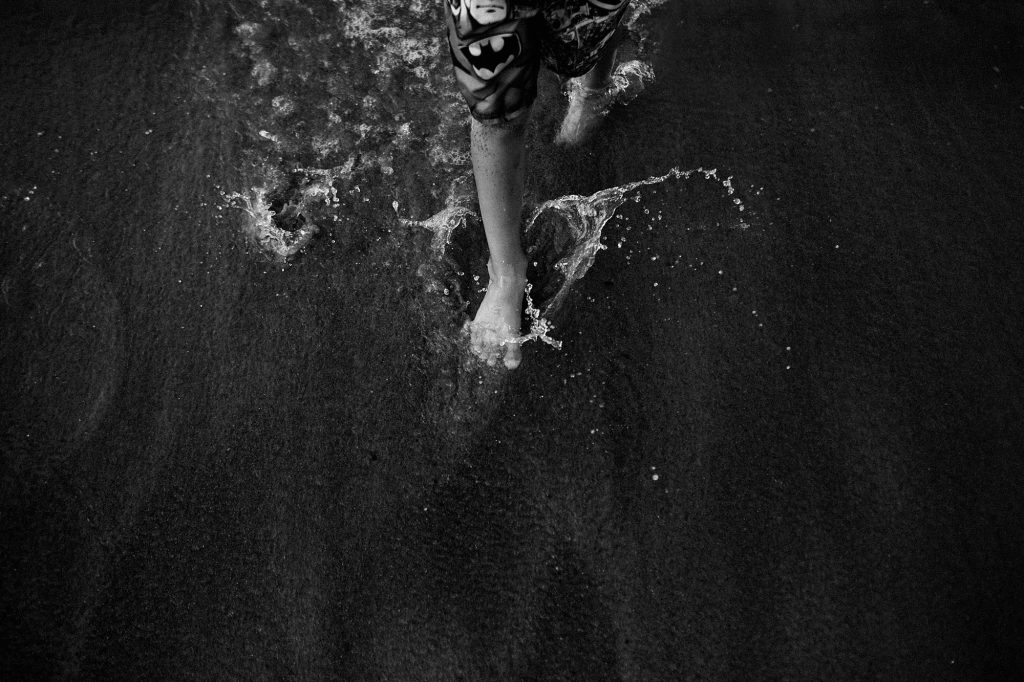 boy running through the water in Maine