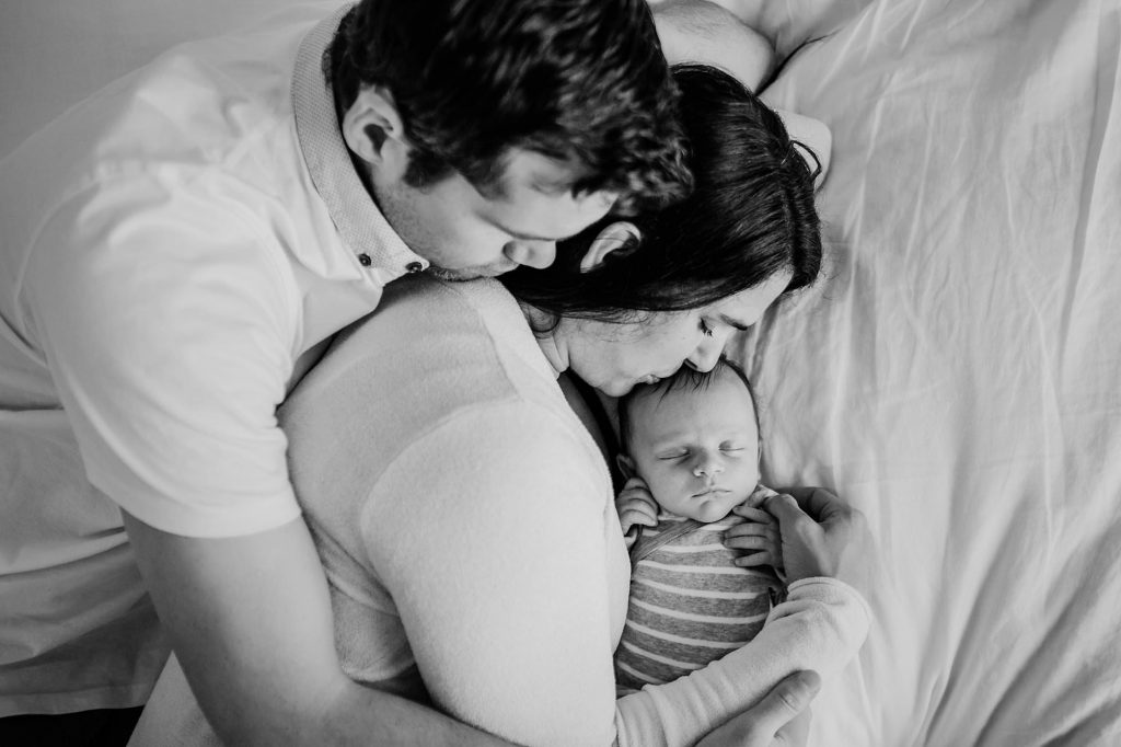 parents laying with baby Charlestown Newborn Photographer