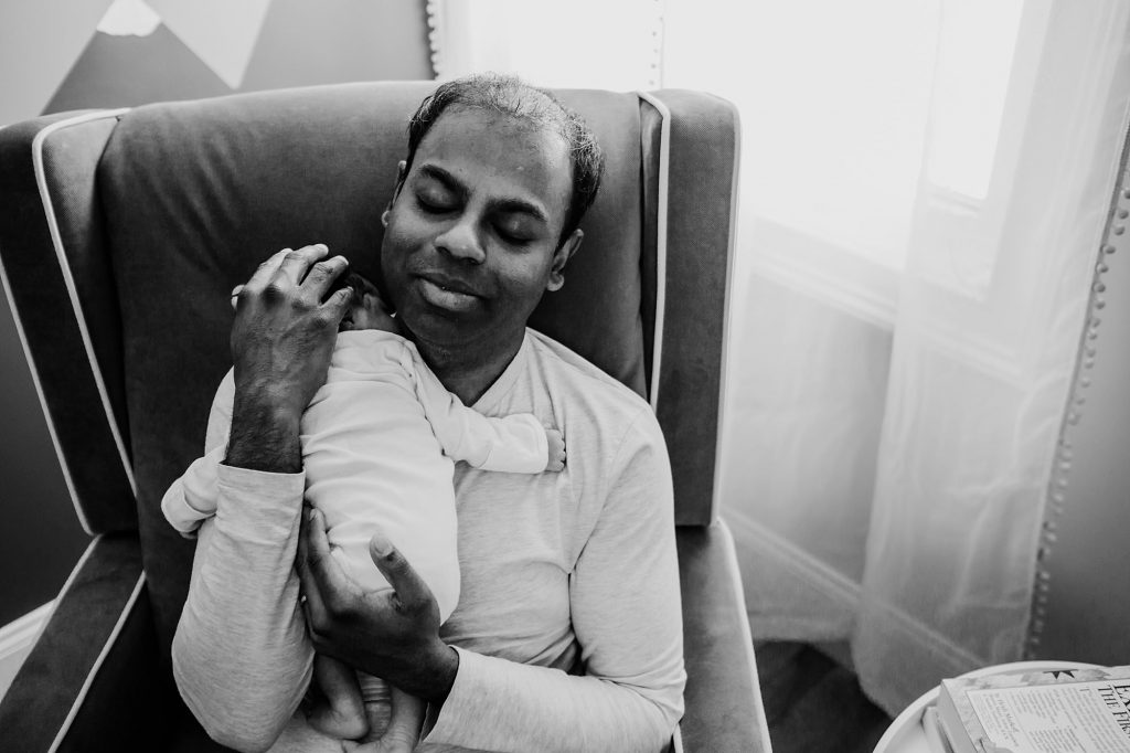dad holding baby in nursery Arlington Newborn Photographer