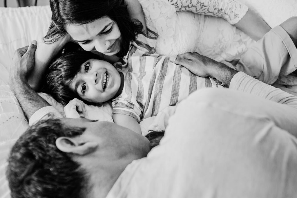 parents snuggling with kids on bed Arlington Newborn Photographer
