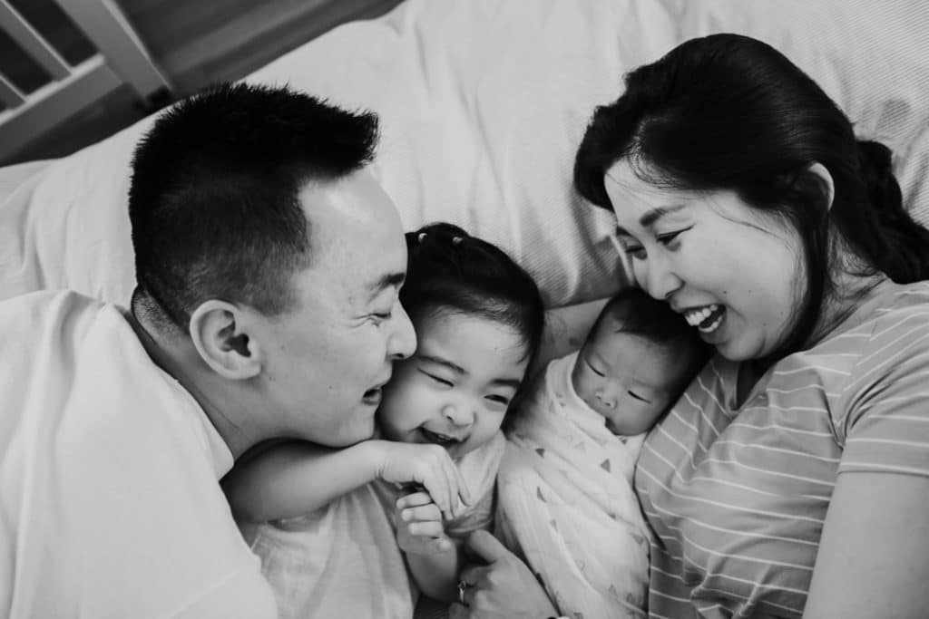 parent laughing with family and baby acton newborn photographer