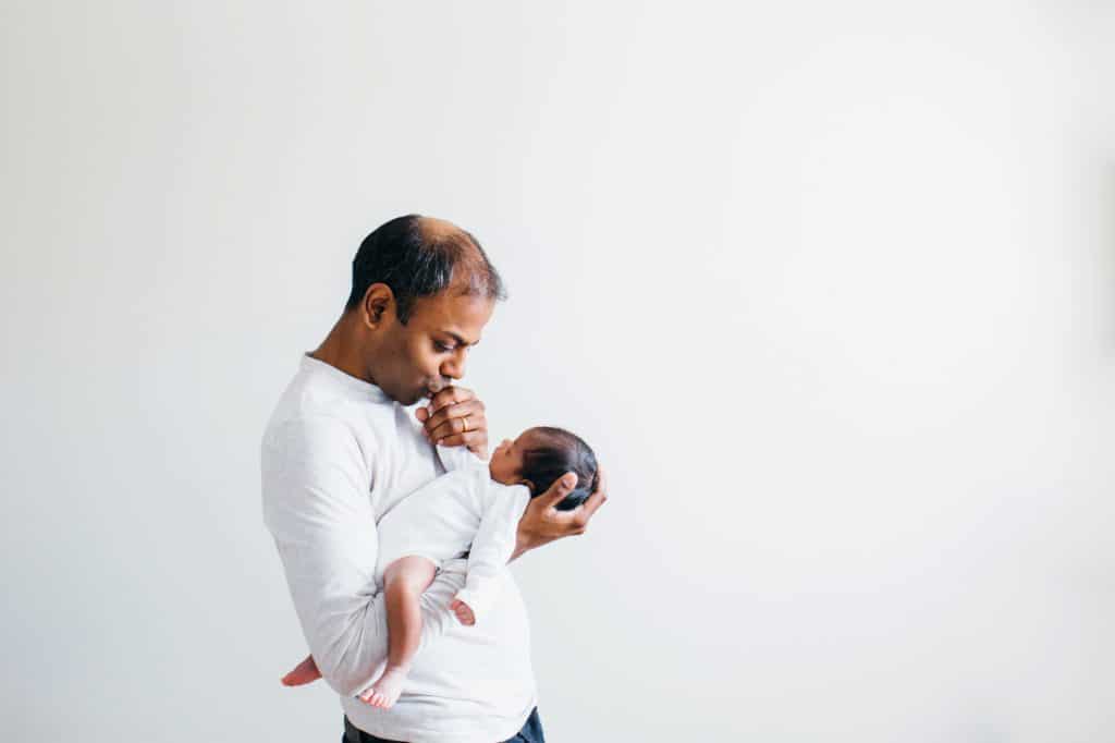 dad kissing newborn's hand arlington baby photographer