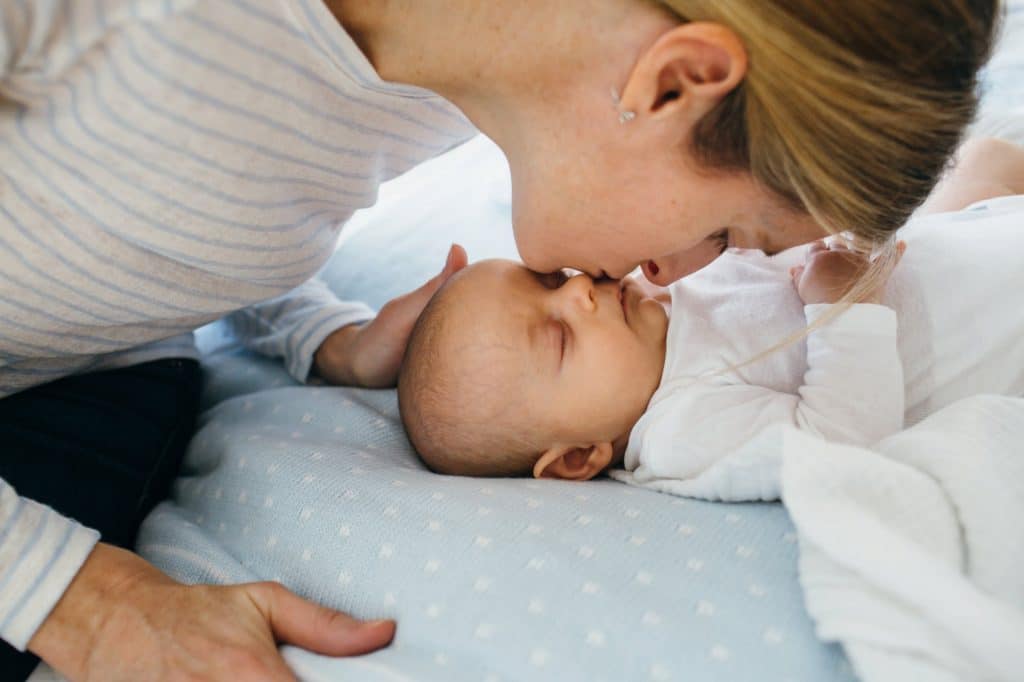 mom kissing sleeping newborn arlington newborn photographer