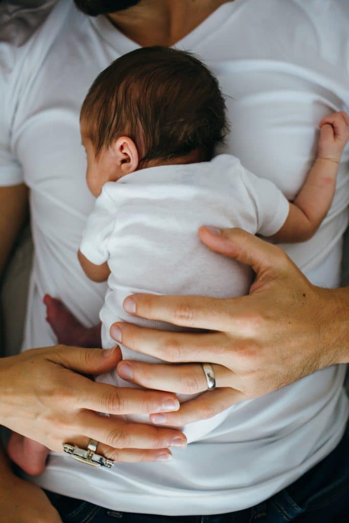 parents' hands on baby belmont newborn photographer