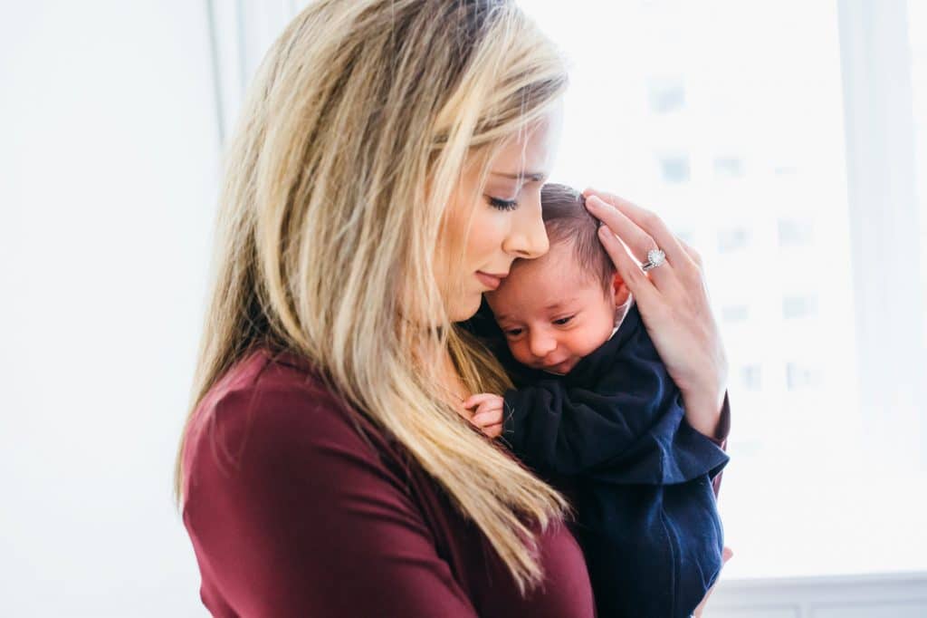 mom holding baby in nursery boston newborn photographer 