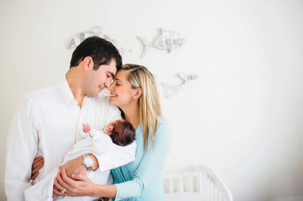 parents holding newborn in nursery boston photographer