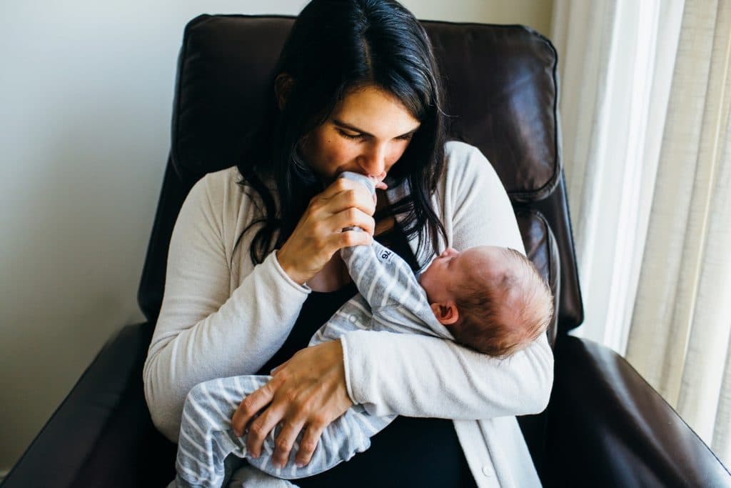 mom kissing baby's hand Boston newborn photographer