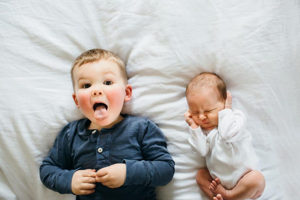 funny photo of baby and big brother dedham newborn photographer