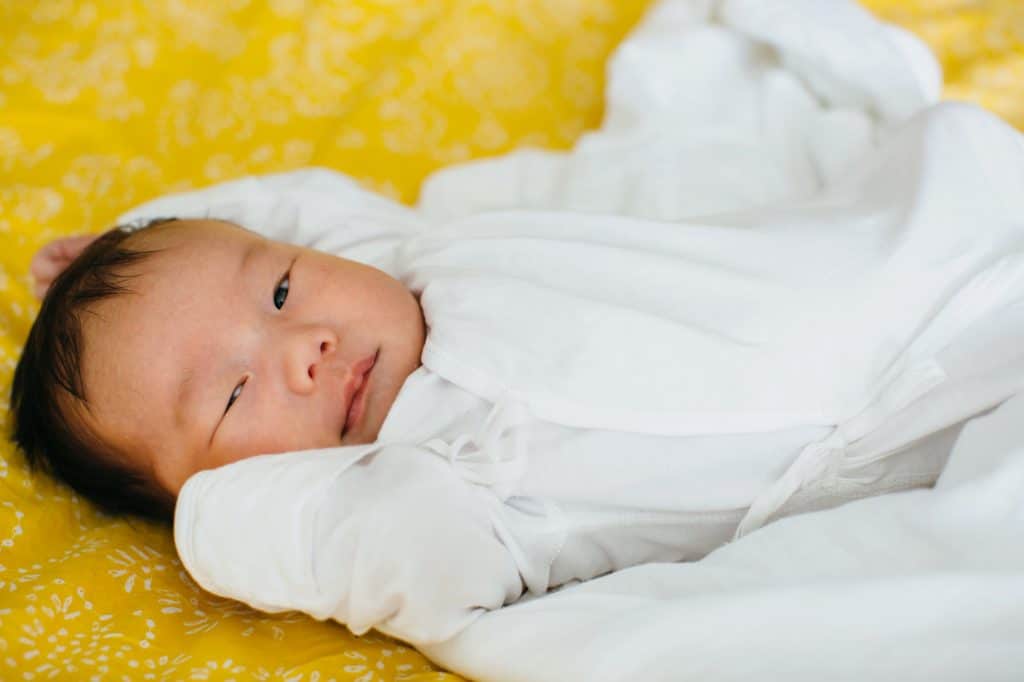 baby winking on yellow blanket lowell newborn photographer