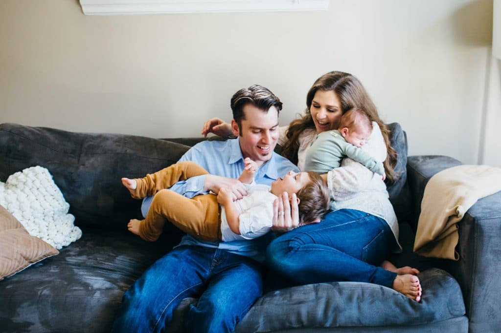 family of four goofy around on the couch medford newborn photographer