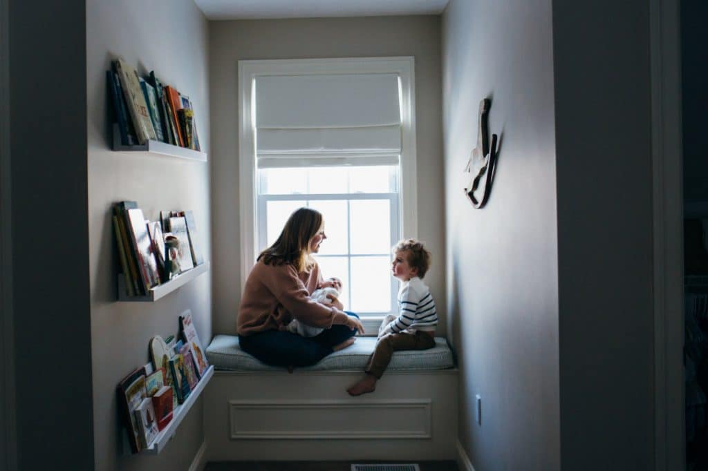 mom with baby and son in window nook north shore newborn photographer