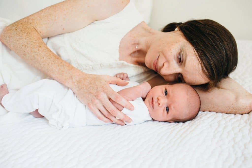 Mom snuggling with baby Concord newborn photographer