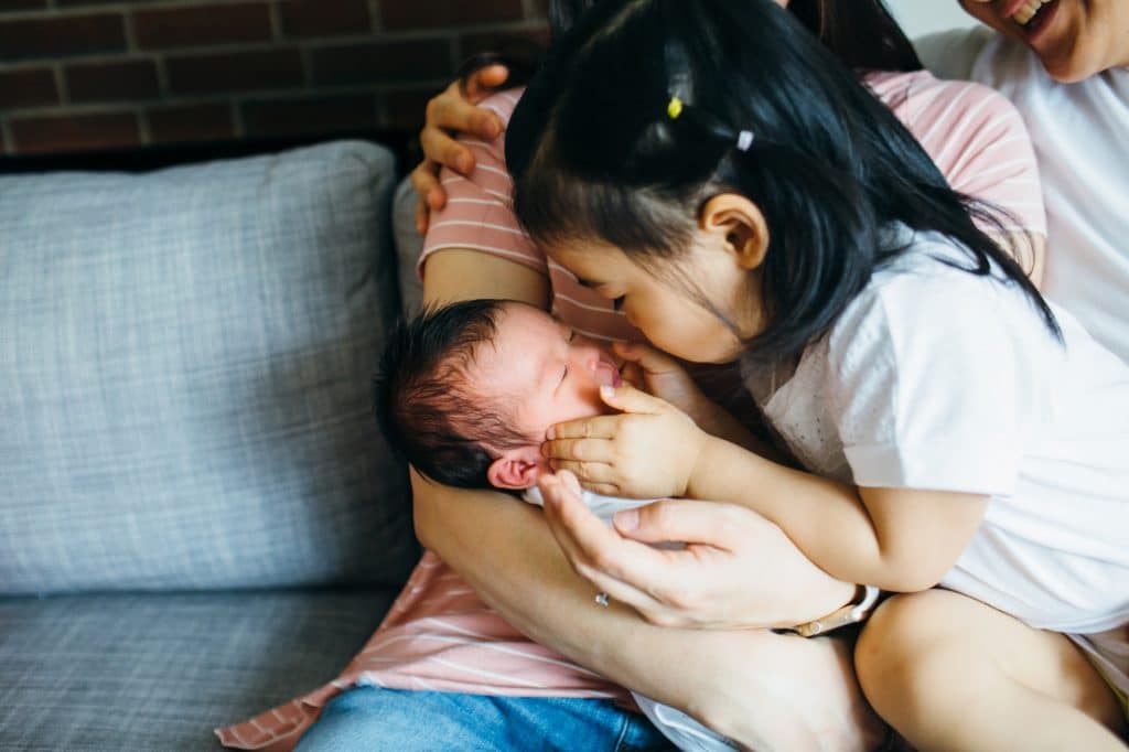 big sister looking at new sister newborn photographer