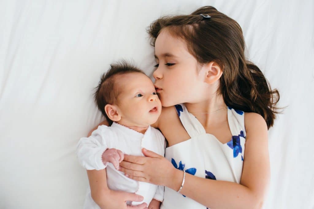 Big sister kissing Weston newborn photographer