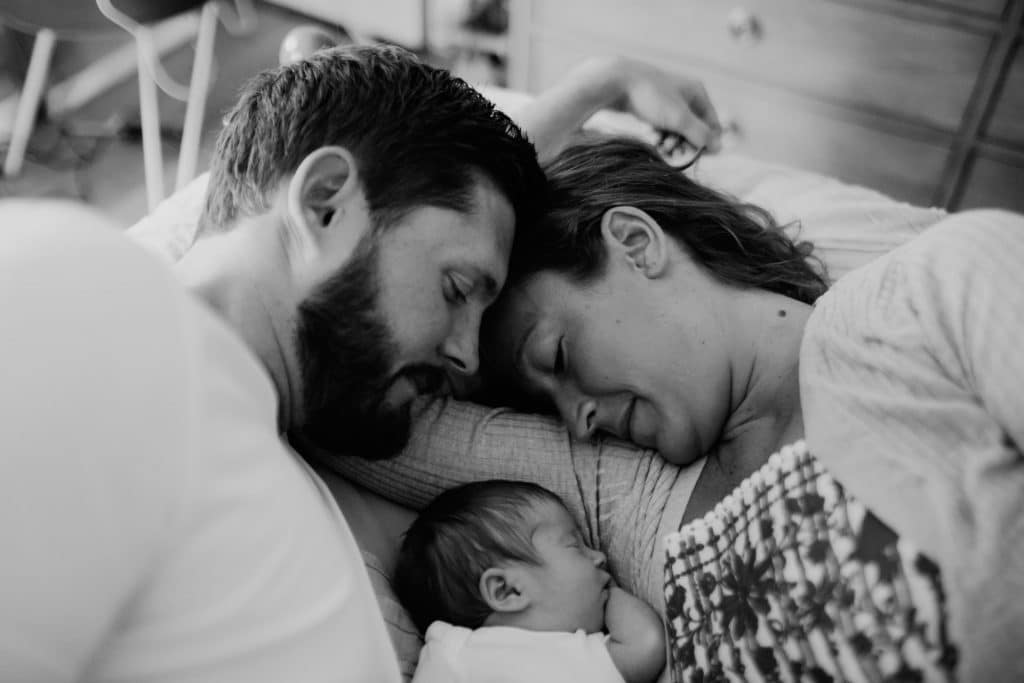 parents snuggling with baby Belmont newborn photographer