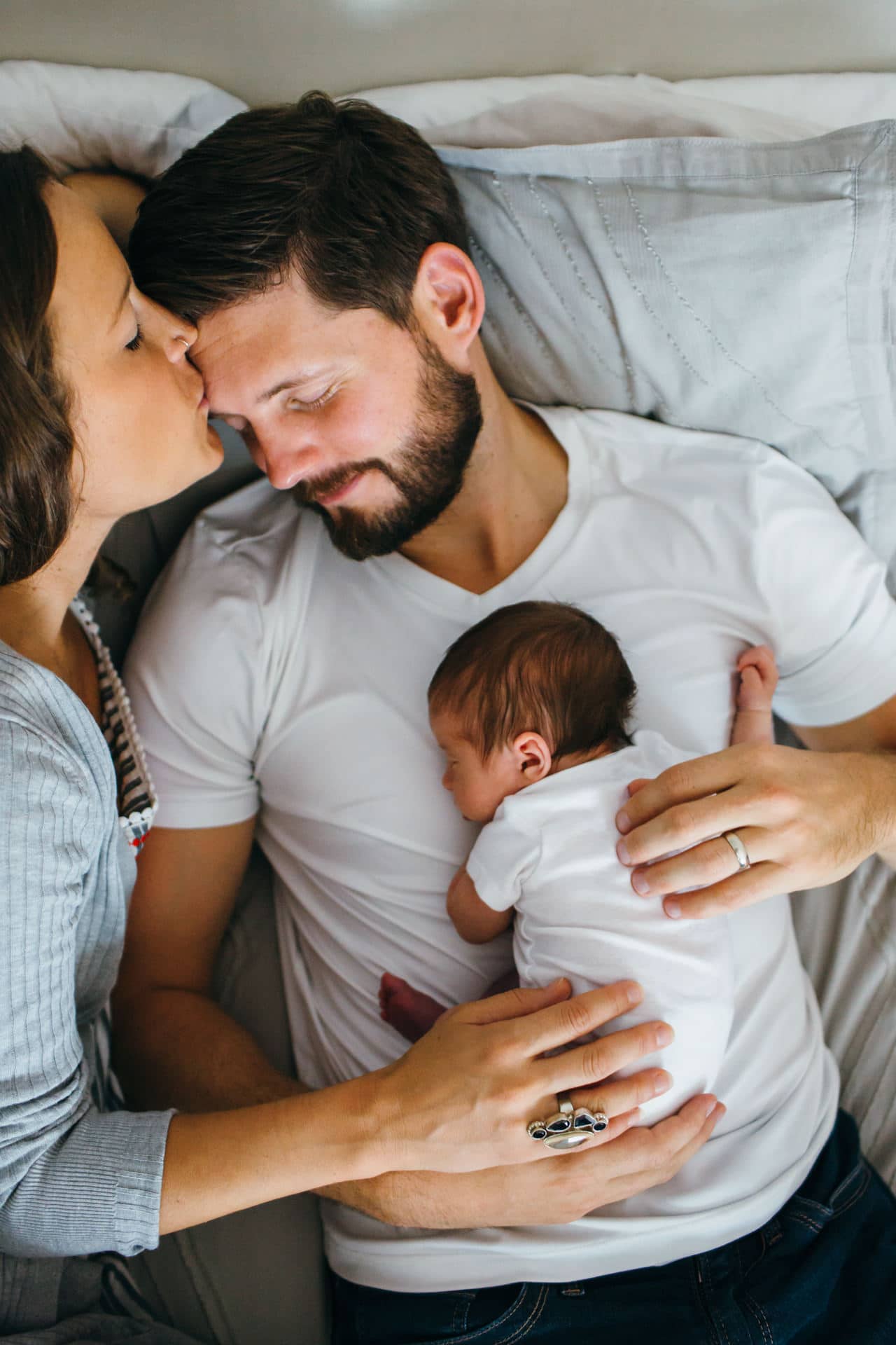parents in bed with baby girl Belmont newborn photos