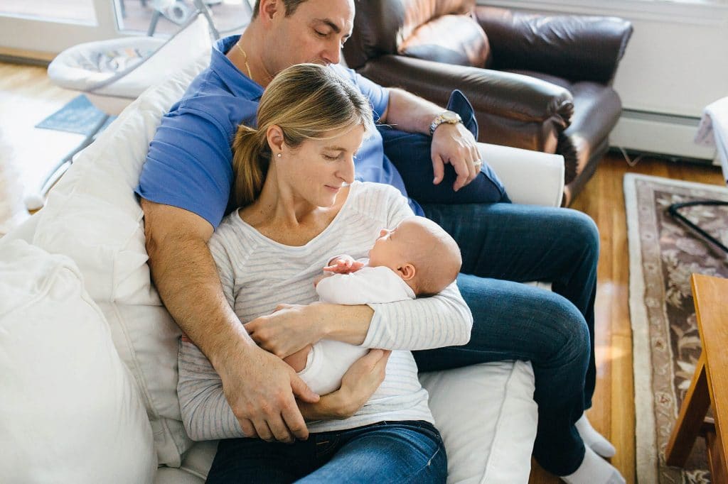 parents hanging out on couch with baby arlington newborn photos