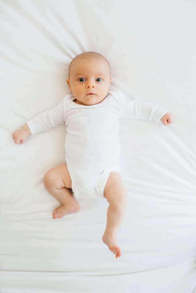 baby laying on bed Arlington Newborn photographer