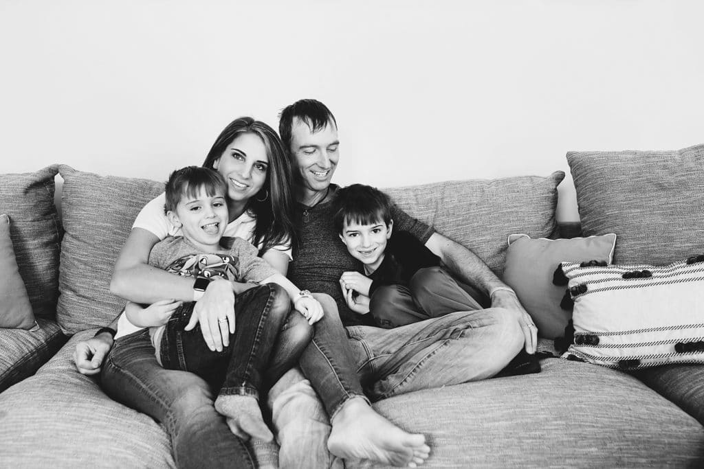 family sitting together smiling on the couch Boston family photographer