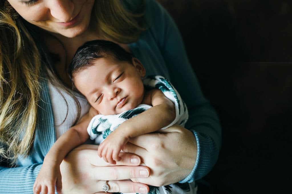 baby curled up in mom's arms Watertown newborn photo