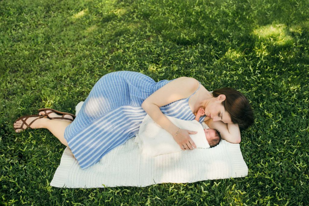mom laying with baby in the grass Boston newborn photographer