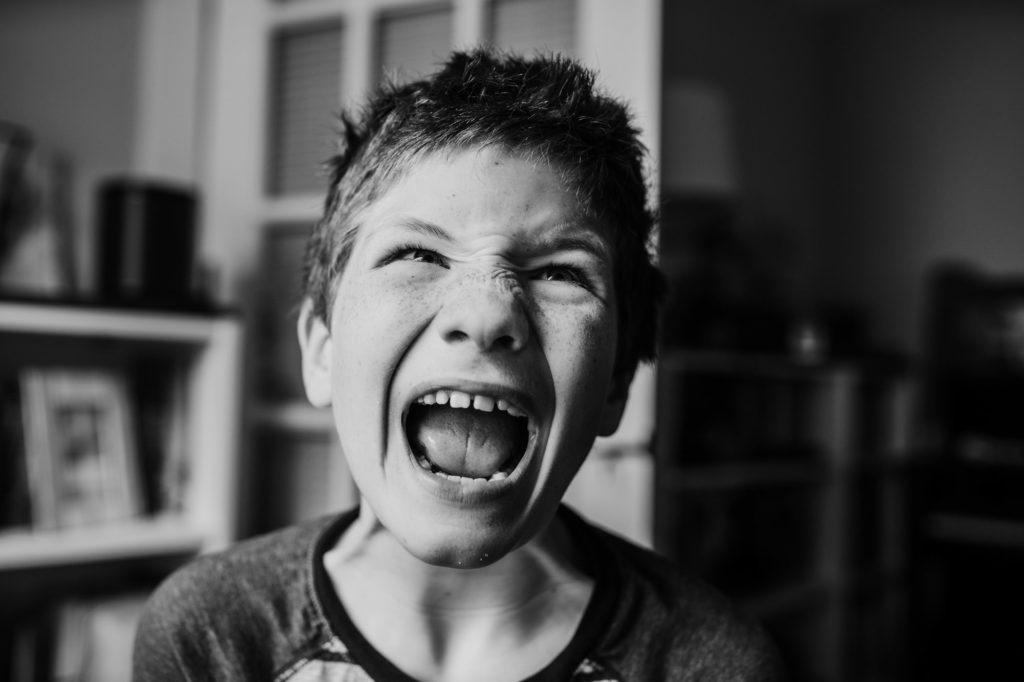 black and white photo of a boy yelling