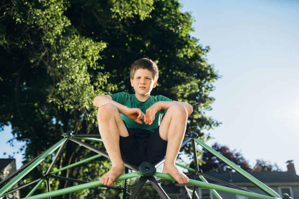 boy sitting on a climbing dome
